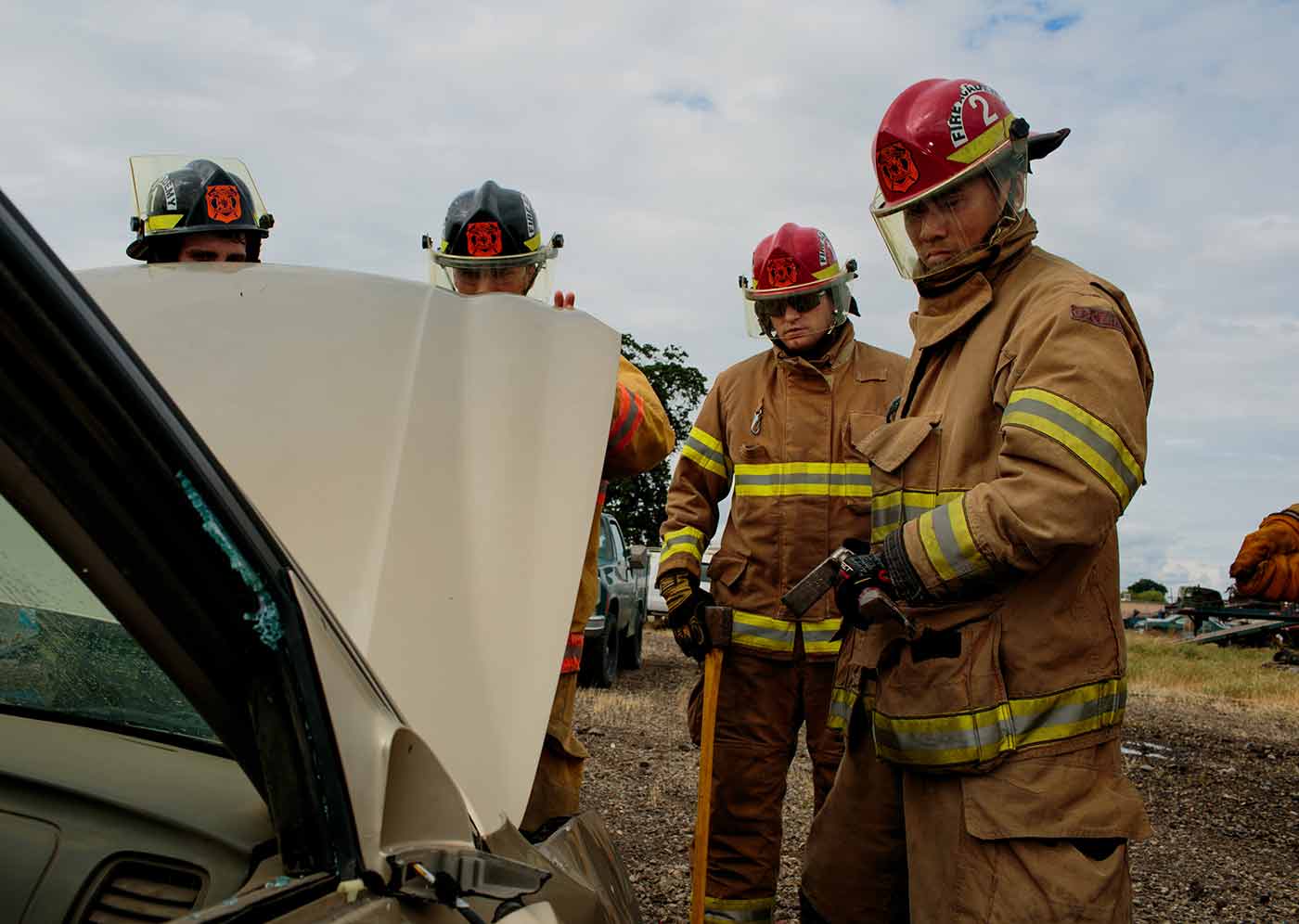 a group of firefighters standing next to a car