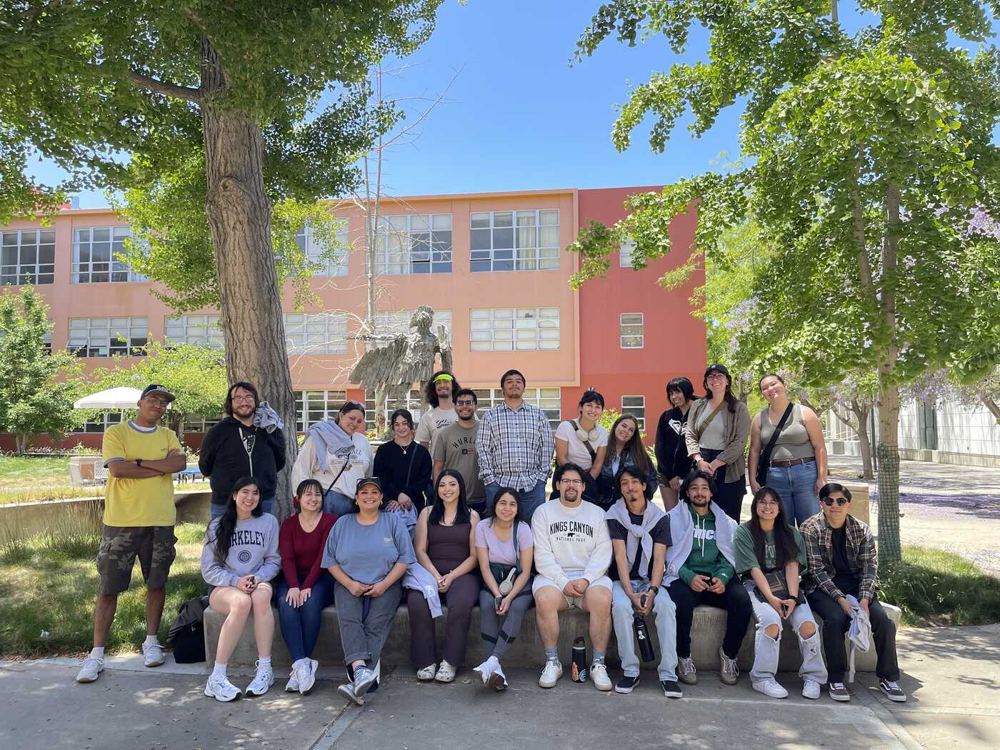 a group of people posing for a photo in front of a brick building