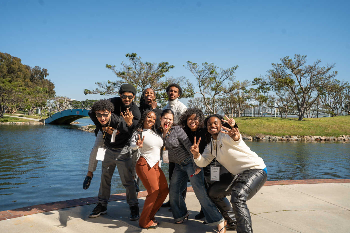 a group of people posing for a photo next to a body of water
